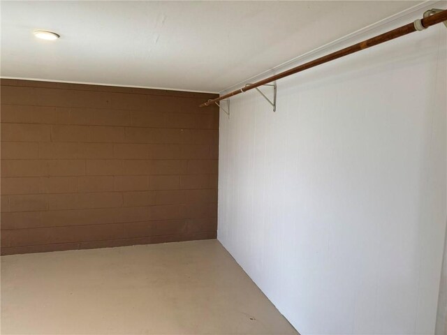 interior space with concrete flooring and concrete block wall