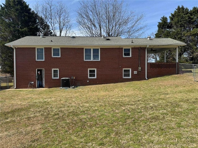 back of house featuring cooling unit, brick siding, a yard, and fence