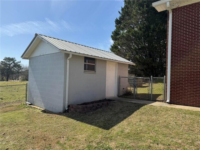 view of outbuilding with an outdoor structure, fence, and a gate