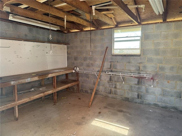 basement featuring concrete block wall and a workshop area