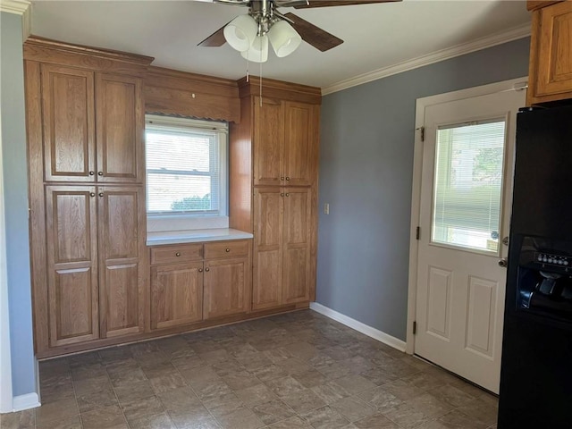 kitchen with baseboards, a ceiling fan, brown cabinets, black refrigerator with ice dispenser, and crown molding