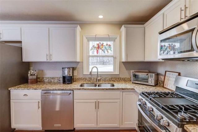 kitchen featuring stainless steel appliances, sink, and white cabinets