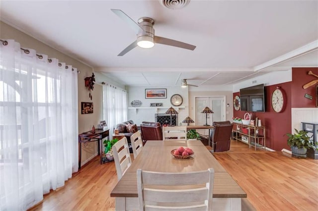 dining space featuring hardwood / wood-style floors, a fireplace, and ceiling fan