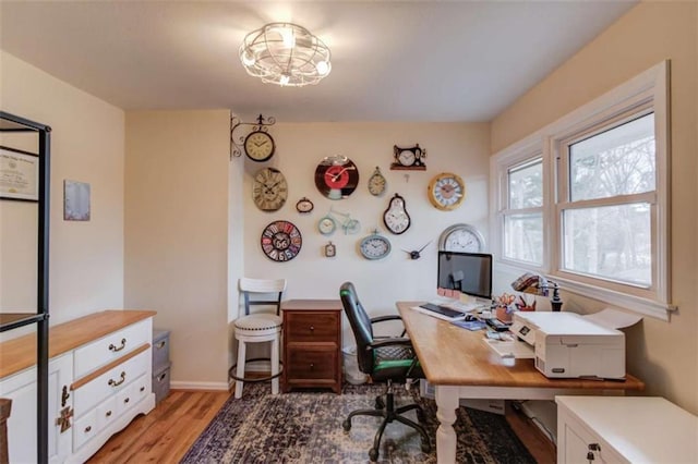 home office with light hardwood / wood-style flooring