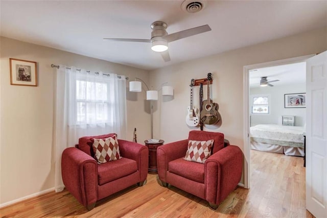 living room with light hardwood / wood-style flooring and ceiling fan