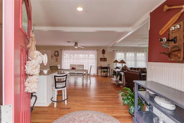 interior space with ceiling fan, beam ceiling, and light hardwood / wood-style flooring