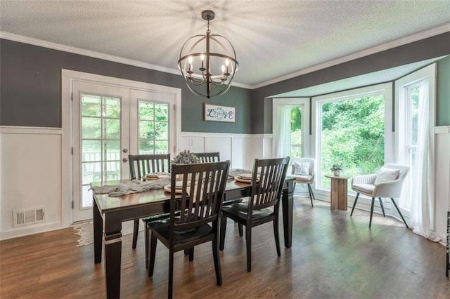 361 Princeton Way, Lawrenceville, GA 30044 - dining area featuring a chandelier, a wainscoted wall, a textured ceiling, ornamental molding, and dark wood-style flooring