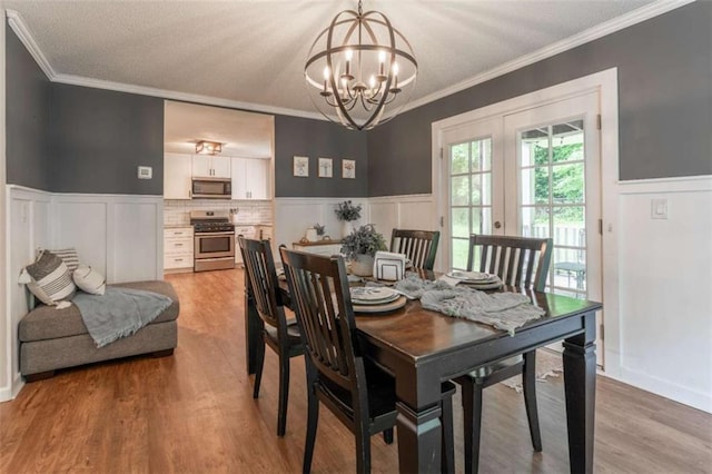 361 Princeton Way, Lawrenceville, GA 30044 - dining area featuring a chandelier, crown molding, a wainscoted wall, light wood-style floors, and french doors