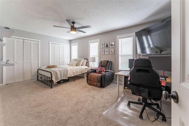 361 Princeton Way, Lawrenceville, GA 30044 - carpeted bedroom featuring multiple closets, an office area, a textured ceiling, and a ceiling fan
