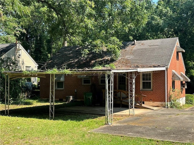 back of house featuring a yard and a carport