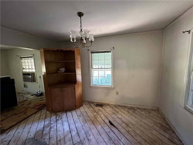 unfurnished dining area featuring ornamental molding, an inviting chandelier, cooling unit, and hardwood / wood-style flooring