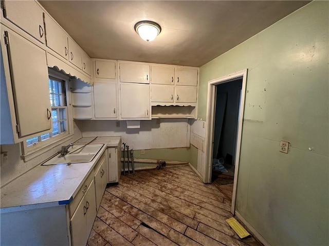 kitchen featuring sink, white cabinetry, and light hardwood / wood-style floors