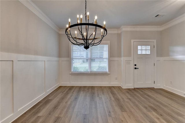 2090 Harvester Ln, Buford, GA 30518 - foyer entrance featuring a chandelier, a decorative wall, a wainscoted wall, wood finished floors, and ornamental molding