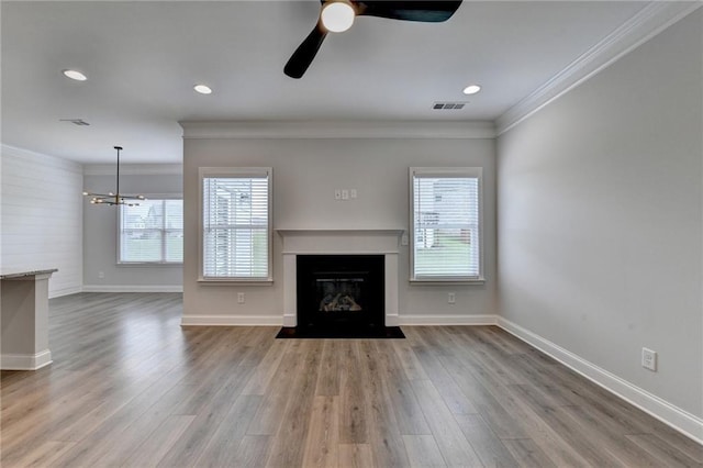 2090 Harvester Ln, Buford, GA 30518 - unfurnished living room featuring crown molding, a ceiling fan, wood finished floors, a chandelier, and a fireplace with flush hearth