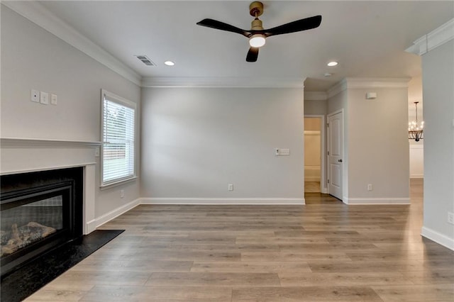 2090 Harvester Ln, Buford, GA 30518 - unfurnished living room featuring a glass covered fireplace, ornamental molding, a ceiling fan, recessed lighting, and a chandelier