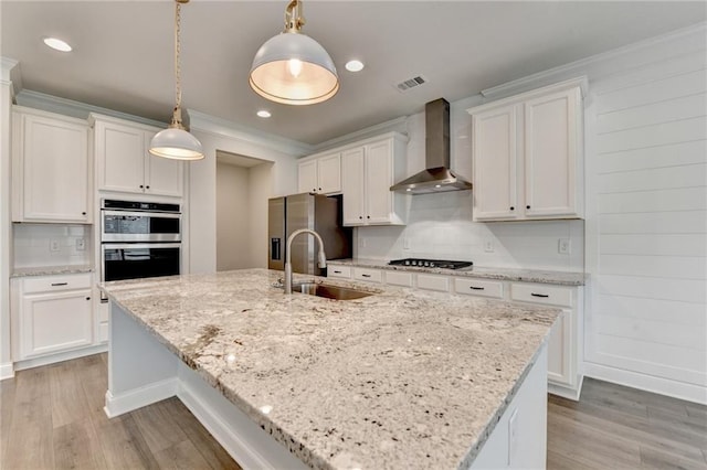 2090 Harvester Ln, Buford, GA 30518 - kitchen with wall chimney range hood, stainless steel appliances, light wood-style flooring, tasteful backsplash, and ornamental molding