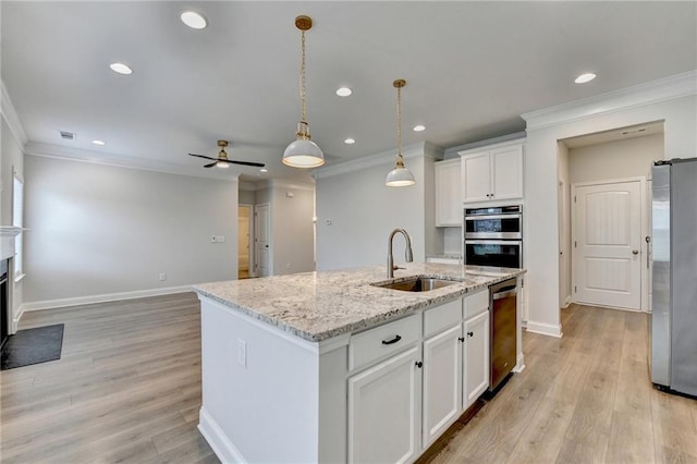 2090 Harvester Ln, Buford, GA 30518 - kitchen featuring stainless steel appliances, ornamental molding, recessed lighting, a kitchen island with sink, and white cabinets