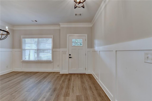 2090 Harvester Ln, Buford, GA 30518 - entrance foyer featuring a chandelier, a decorative wall, a wainscoted wall, light wood-type flooring, and plenty of natural light