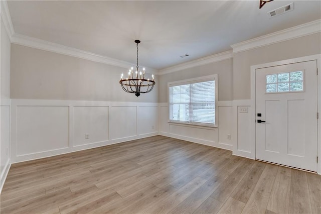 2090 Harvester Ln, Buford, GA 30518 - foyer featuring a decorative wall, a chandelier, light wood-type flooring, a wainscoted wall, and crown molding