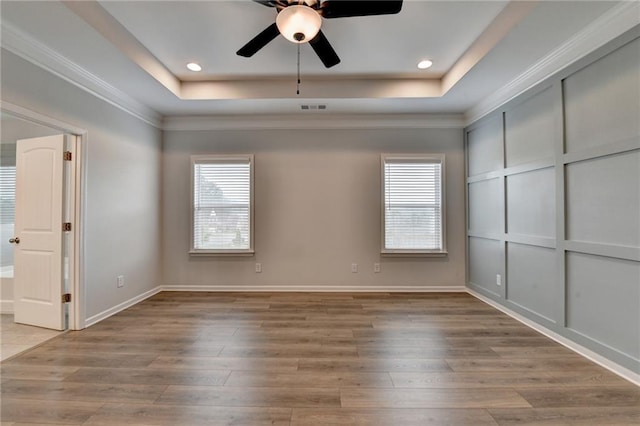 2090 Harvester Ln, Buford, GA 30518 - unfurnished bedroom with multiple windows, wood finished floors, a tray ceiling, ornamental molding, and recessed lighting
