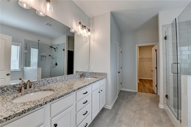 2090 Harvester Ln, Buford, GA 30518 - full bath featuring a stall shower, double vanity, a spacious closet, and tile patterned flooring
