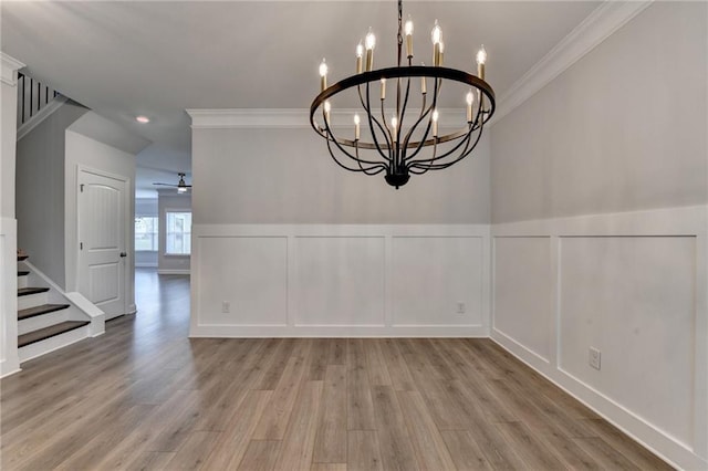 2090 Harvester Ln, Buford, GA 30518 - unfurnished dining area featuring a decorative wall, crown molding, wood finished floors, stairs, and a chandelier