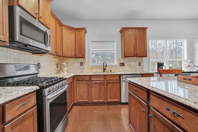 kitchen featuring sink, backsplash, plenty of natural light, and stainless steel appliances