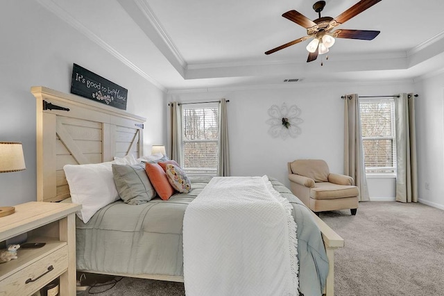 bedroom with ornamental molding, carpet flooring, ceiling fan, and a tray ceiling