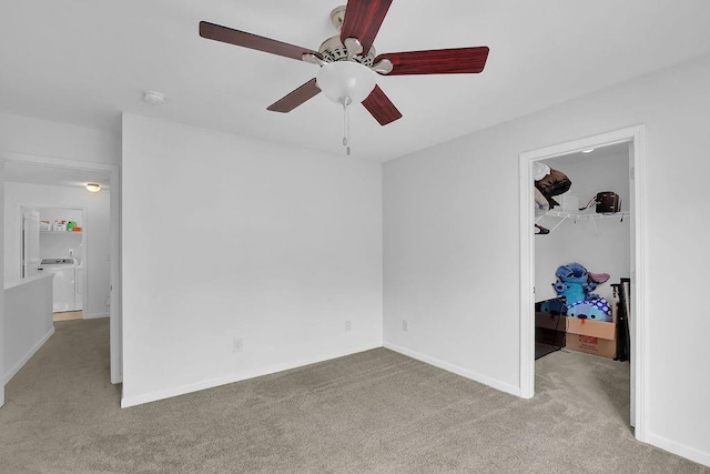 carpeted empty room with washer / clothes dryer and ceiling fan