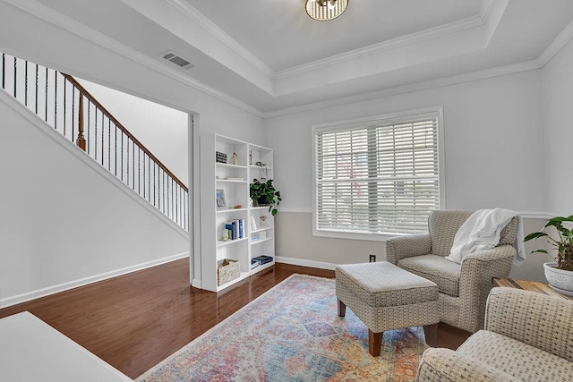 sitting room featuring crown molding, a tray ceiling, and dark hardwood / wood-style flooring