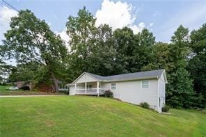 view of front of property with a porch and a front lawn