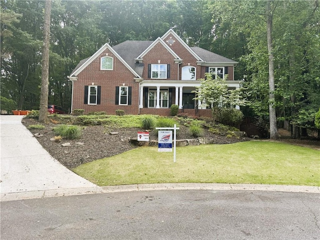 view of front of home with brick siding and a front yard