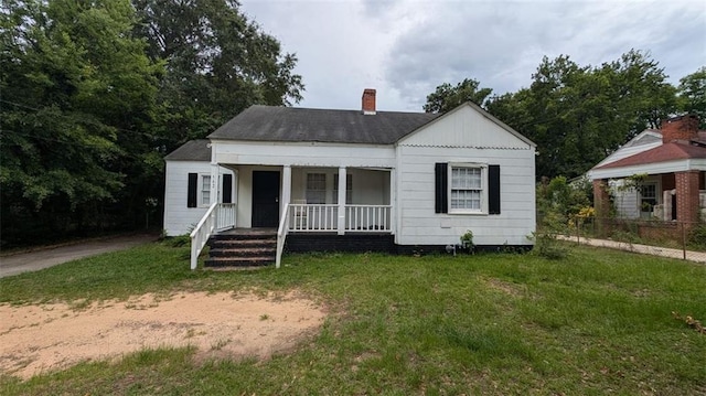 view of front facade with a front yard and covered porch