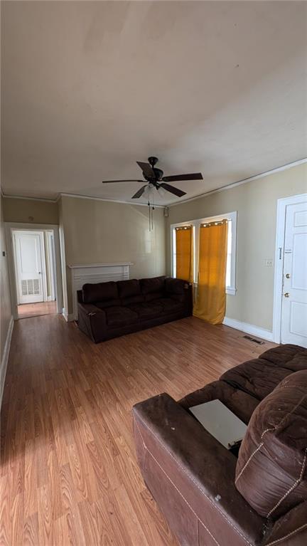 unfurnished living room featuring crown molding, light hardwood / wood-style flooring, and ceiling fan