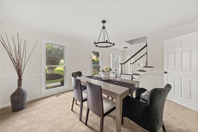 179 Hunters Crk, Dallas, GA 30157 - dining space featuring a chandelier, light colored carpet, stairs, and ornamental molding