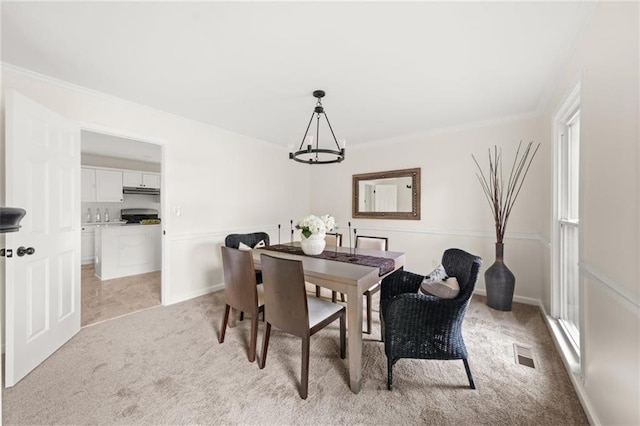 179 Hunters Crk, Dallas, GA 30157 - dining area featuring light carpet, a chandelier, and crown molding