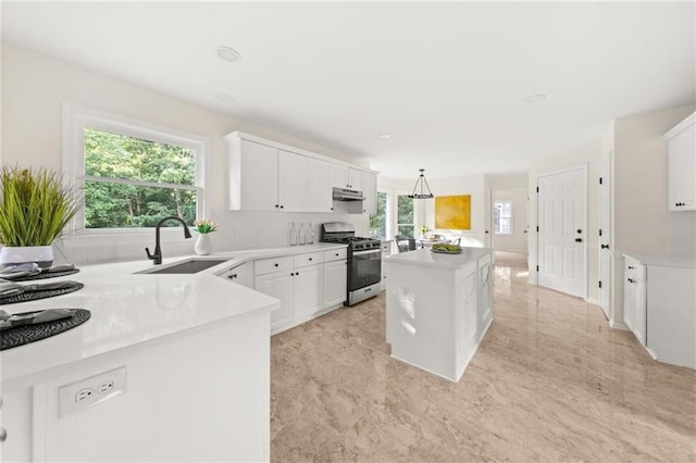 179 Hunters Crk, Dallas, GA 30157 - kitchen featuring stainless steel range with gas stovetop, a kitchen island, white cabinets, and light countertops