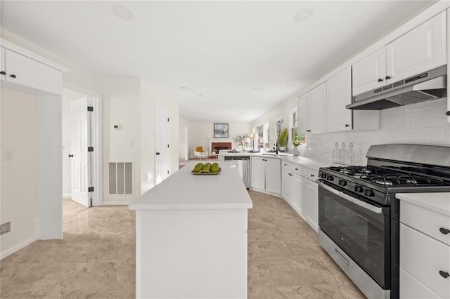 179 Hunters Crk, Dallas, GA 30157 - kitchen with appliances with stainless steel finishes, under cabinet range hood, a kitchen island, and white cabinetry