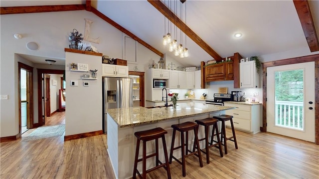 kitchen featuring white cabinets, a sink, stainless steel appliances, light wood-style floors, and beam ceiling