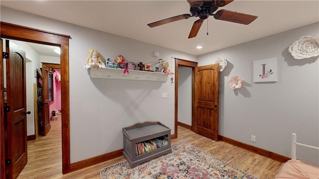 bedroom with a ceiling fan, light wood-type flooring, and baseboards