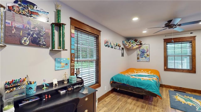 bedroom with baseboards, wood finished floors, and recessed lighting