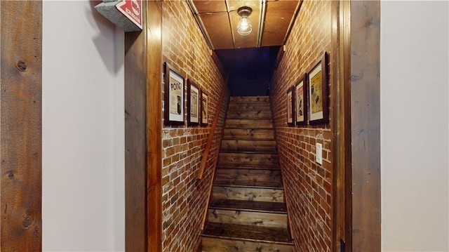 hallway featuring brick wall