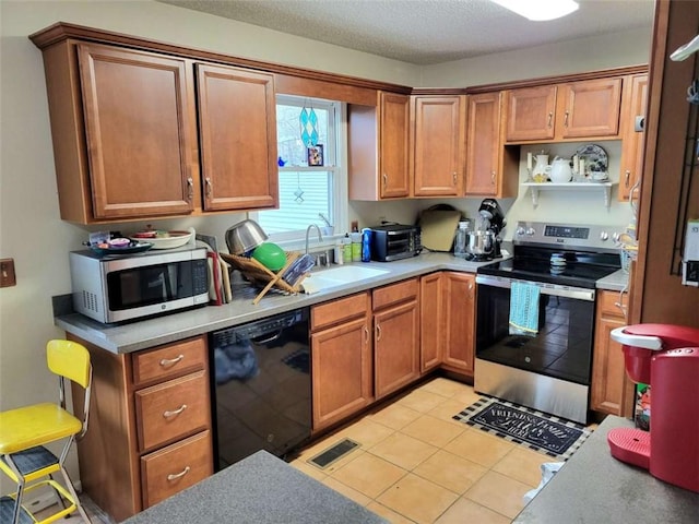 kitchen featuring visible vents, light countertops, light tile patterned floors, appliances with stainless steel finishes, and a sink