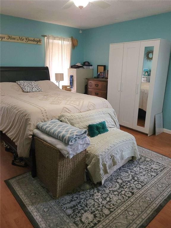 bedroom with a closet, a ceiling fan, and wood finished floors