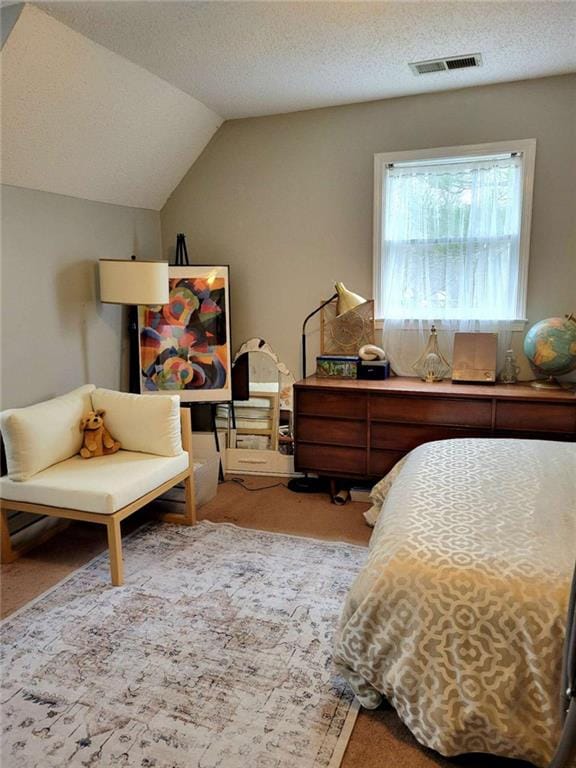 bedroom featuring lofted ceiling, carpet, visible vents, and a textured ceiling