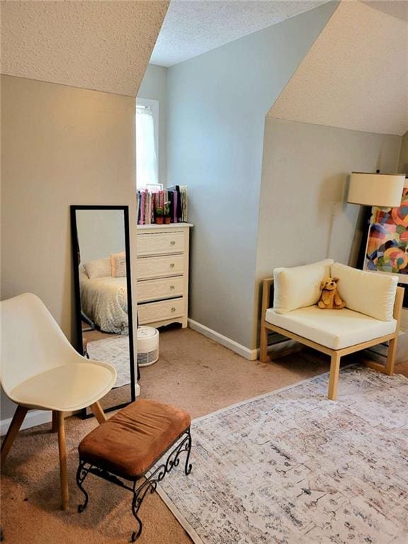 living area featuring vaulted ceiling, a textured ceiling, baseboards, and carpet floors