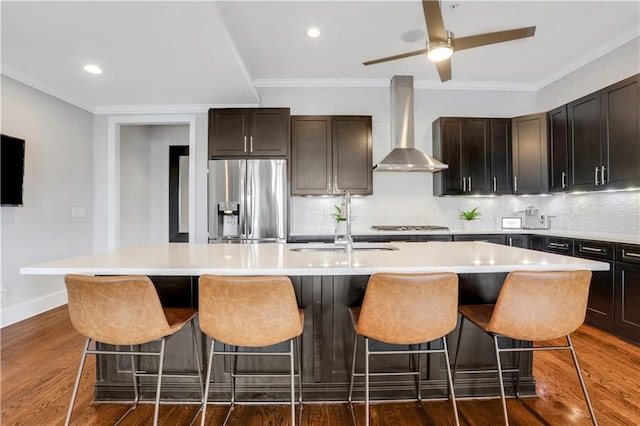 4550 Lois St SE, Smyrna, GA 30080 - kitchen featuring stainless steel appliances, wall chimney range hood, a sink, decorative backsplash, and an island with sink