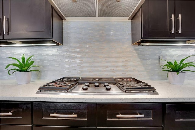 4550 Lois St SE, Smyrna, GA 30080 - kitchen with stainless steel gas stovetop, dark brown cabinets, decorative backsplash, and custom range hood