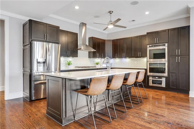 4550 Lois St SE, Smyrna, GA 30080 - kitchen featuring wall chimney range hood, appliances with stainless steel finishes, a sink, light countertops, and a ceiling fan