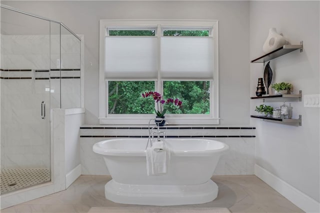 4550 Lois St SE, Smyrna, GA 30080 - full bathroom featuring a soaking tub, a stall shower, marble finish flooring, tile walls, and wainscoting